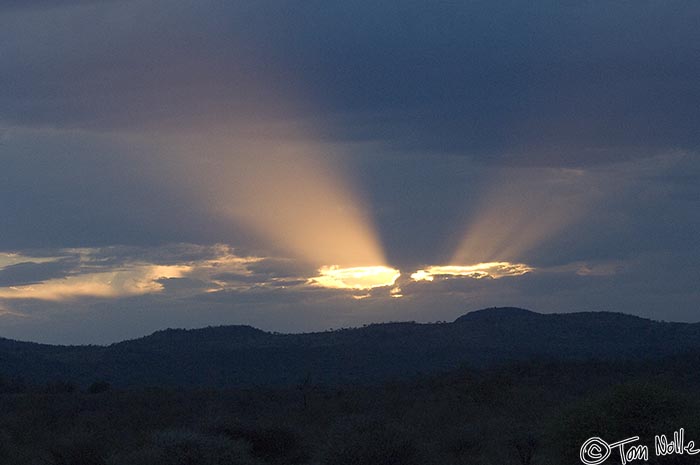 Africa_20081029_121556_614_2X.jpg - Light beams through two holes in the cloud bank make this sunset spectacular.  Madikwe Reserve, South Africa.