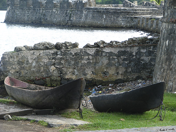 CostaRica_20100317_101646_048_S.jpg - Two old boats, apparently carved from trees, sit idle by the old walls of the fort.  Portobelo, Panama.