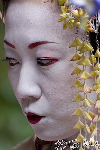 Japan_20080411_014108_388_2X.jpg - A woman made up as a geisha ponders a shopping choice as watchers ponder the glimpse she offers into Japan's classical past.  Tenryu-Ji Kyoto Japan.