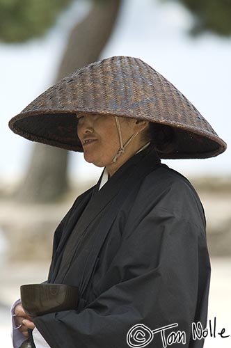 Japan_20080421_220728_974_2X.jpg - A Buddhist with a begging bowl stands near the harbor in Miyajima, Japan.