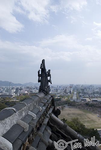 Japan_20080414_014150_532_20.jpg - The gargoyle on the roof of Himeji Castle stands against the modern city of Kobe Japan.