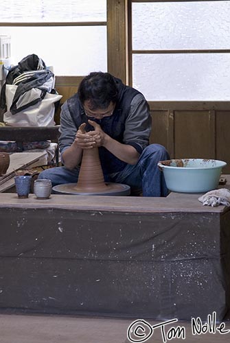 Japan_20080420_215644_419_20.jpg - A potter concentrates on a critical part of the turning of his wares, and almost seems to be praying for success.  Hagi, Japan