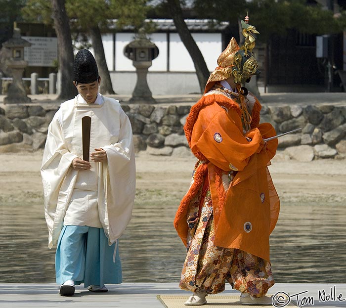 Japan_20080421_204852_931_2X.jpg - Passing a Shinto priest who likely doesn't want to be photographed in this or any context, the dancer exits the stage.  Itsukushima shrine, Miyajima, Japan.